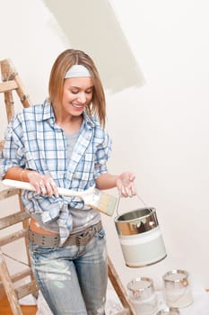 Home improvement: Smiling woman with paint and brush