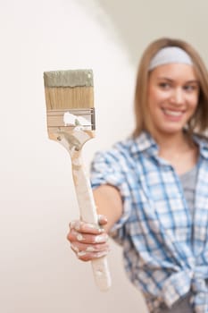 Home improvement: Young woman with paint brush, focus on hand