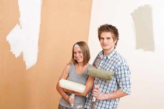 Home improvement: Young man and woman painting wall with paint roller