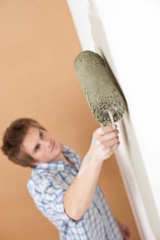 Home improvement: Young man with paint roller painting wall