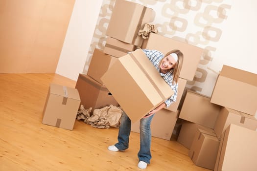 Moving house: Woman holding big carton box in new home