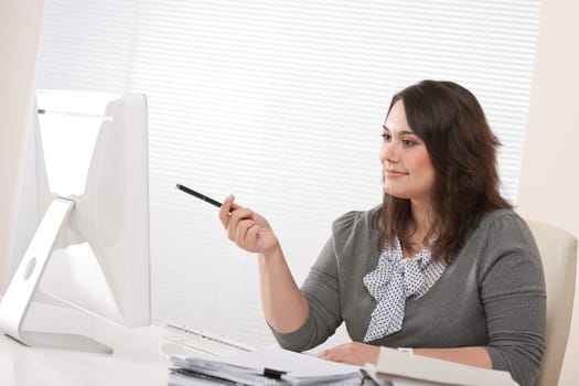 Young business woman working with computer at office sitting at desk