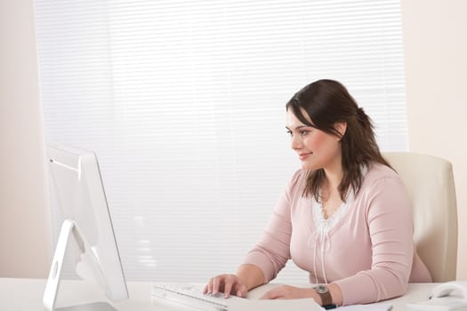 Young female executive working with computer at modern office