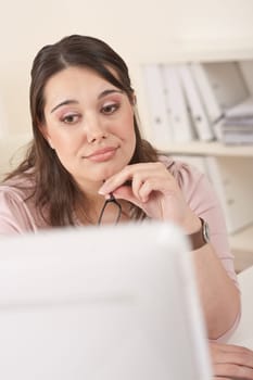 Young businesswoman watching computer screen at office, thinking