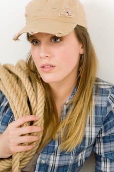 Fashion model - young woman country style posing with rope