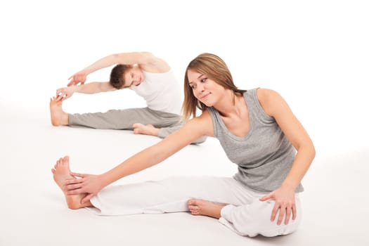 Fitness - Healthy couple stretching after training on white background