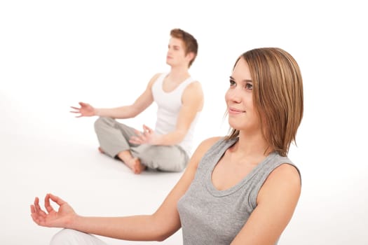 Fitness - Young healthy couple in yoga position on white background