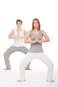 Fitness - Young healthy couple in yoga position on white background