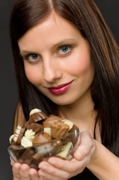 Chocolate - portrait of young woman hold candy in bowl