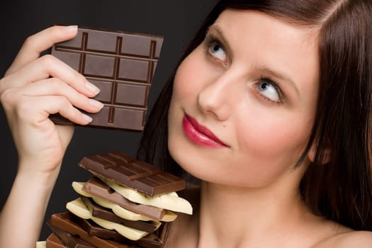 Chocolate - portrait of healthy woman enjoy sweets on black background