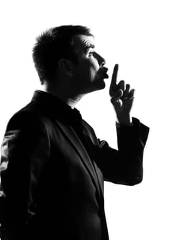 silhouette caucasian business man  hushing silence profile finger on lips full length on studio isolated white background