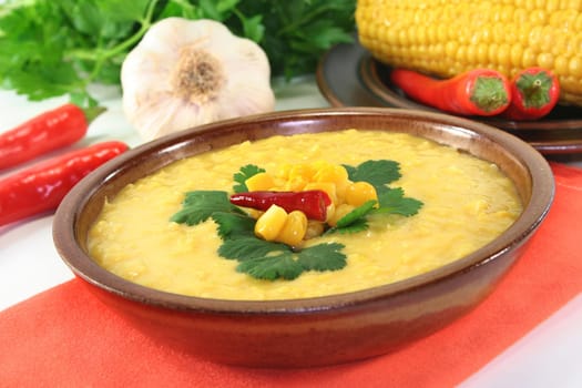 a bowl of corn soup with chili and coriander