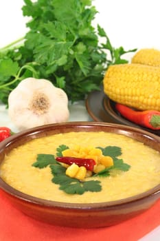 a bowl of corn soup with chili and coriander