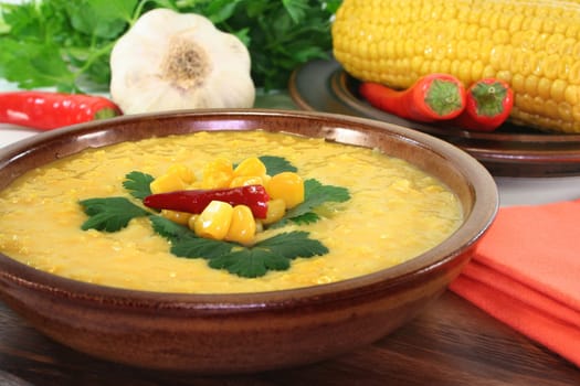 a bowl of corn soup with chili and coriander