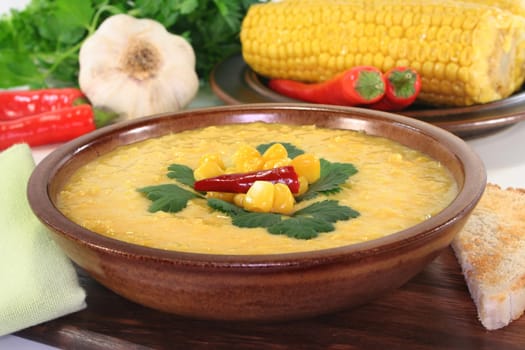 a bowl of corn soup with chili and coriander