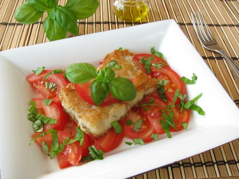 Fish on tomatoes with basil