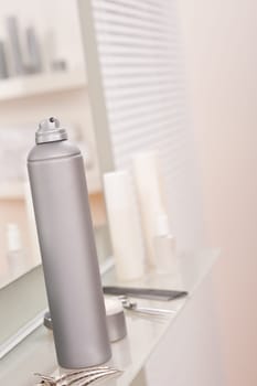 Professional hairdresser studio with hairspray and hair clip, reflection in mirror