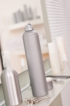 Professional hairdresser studio with hairspray and hair clip, reflection in mirror