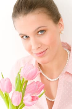 Fashion - young romantic woman with spring tulips in designer clothes