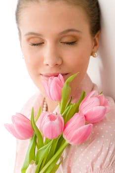 Fashion - young romantic woman with spring tulips in designer clothes