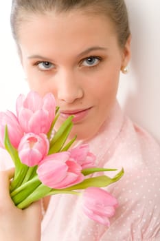 Fashion - young romantic woman with spring tulips in designer clothes