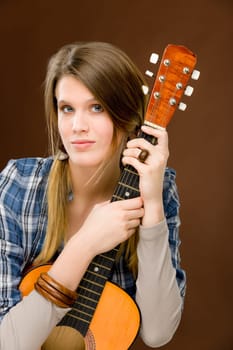 Rock musician - young fashion female model posing with guitar