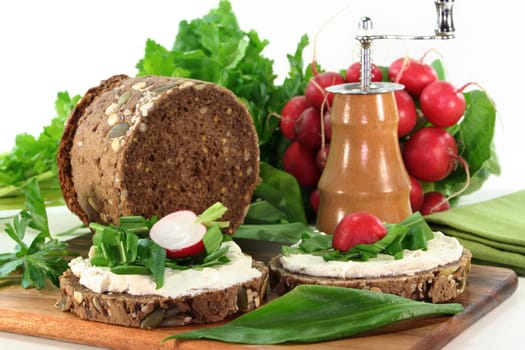 a slice of bread topped with cream cheese and fresh wild garlic