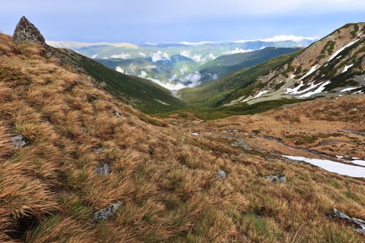 a mountain valley with clouds in the distance