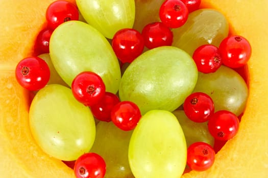 Grapes and currants in a hole of melon