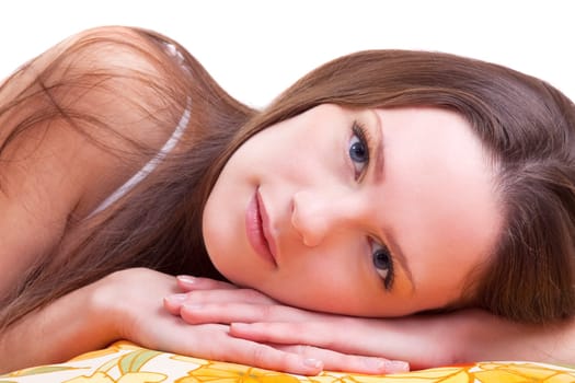 Young woman lay on color pillow slose-up portrait
