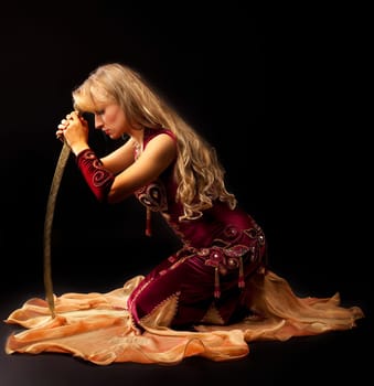 woman in arabian costume sit with saber dramatic appearance