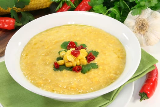 a bowl of corn soup with chili and coriander