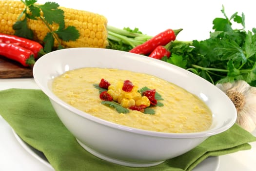 a bowl of corn soup with chili and coriander