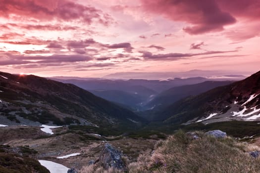a mountain valley and a red sky with clouds