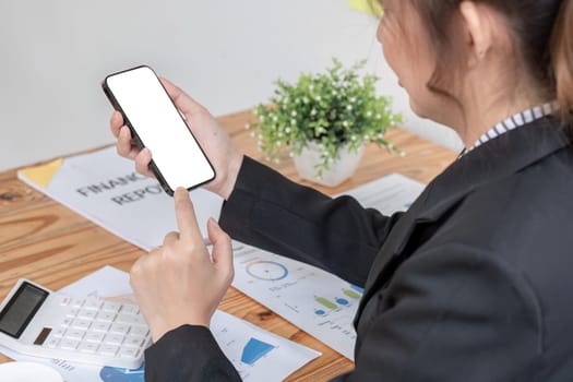Woman holding phone showing white screen on top view while sitting in office.