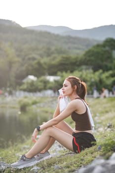 portrait of beautiful asian woman Wipe off your sweat after an evening jog in the park..