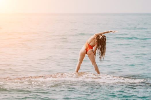 Woman sea yoga. Back view of free calm happy satisfied woman with long hair standing on top rock with yoga position against of sky by the sea. Healthy lifestyle outdoors in nature, fitness concept.