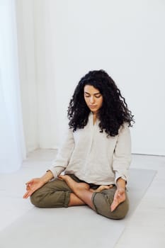 woman doing exercises yoga asana lotus pose workout in the studio