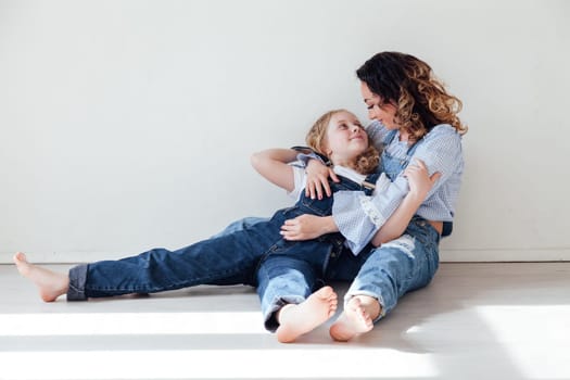 Mother and daughter in a bright room on a white background