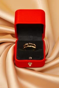 Golden ring in red jewelry box close up studio shot