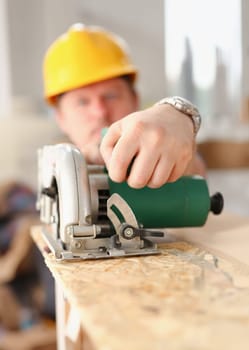 Worker using electric saw portrait. Manual job workplace DIY inspiration improvement fix shop yellow helmet hard hat joinery startup idea industrial education profession career concept