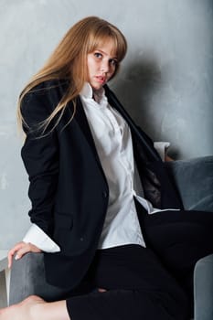 red-haired woman posing on gray armchair