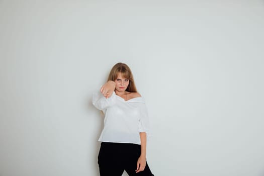 Woman showing index finger on light background