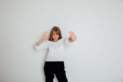 Woman shows OK on a light background