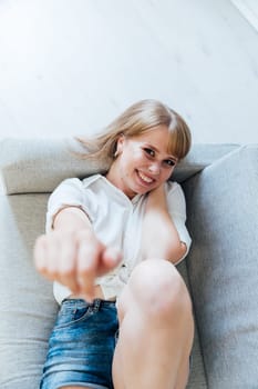 woman lying on couch in room with outstretched hand