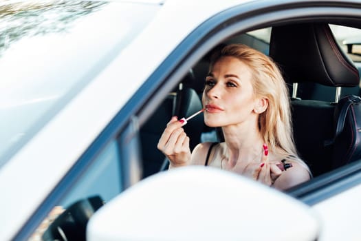 Woman painting lips while driving a car