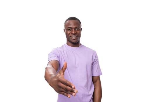 young funny smiling american guy dressed in a cotton t-shirt on a white background with copy space.