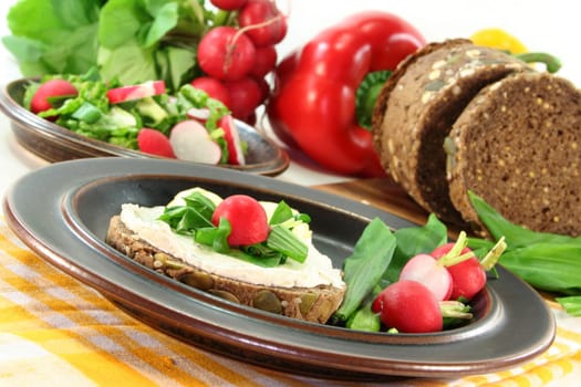 a slice of bread topped with cream cheese and fresh wild garlic
