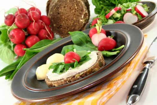 a slice of bread topped with cream cheese and fresh wild garlic