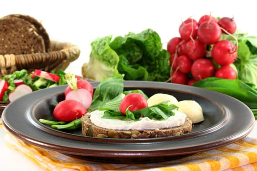a slice of bread topped with cream cheese and fresh wild garlic